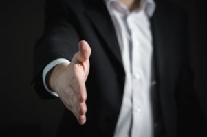 man in suit reaching out hand for handshake